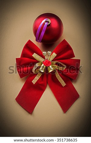 Red bow bauble on golden background holidays concept.