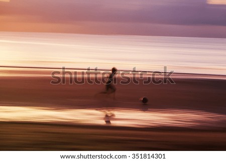 kids play football on beach at sunset