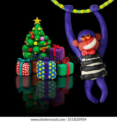 Christmas fir tree  plasticine cartoon with gift boxes and new year monkey on a black background