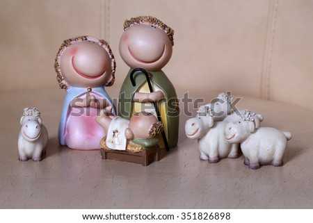 Closeup view of decorative celebrating Christmas and Jesus birth figurines of holy virgin Mary Joseph newborn child with few white sheeps standing on wooden background, horizontal picture