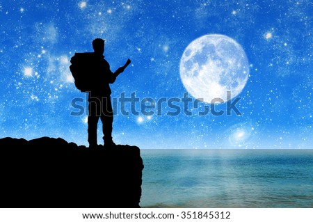 Concept of tourism and travel. Silhouettes of tourists in the mountains in the night sky and the sea
