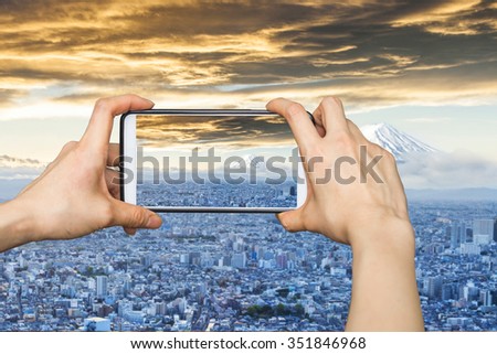 Taking pictures on mobile smart phone in Mount Fuji and Japan cityscape in twilight