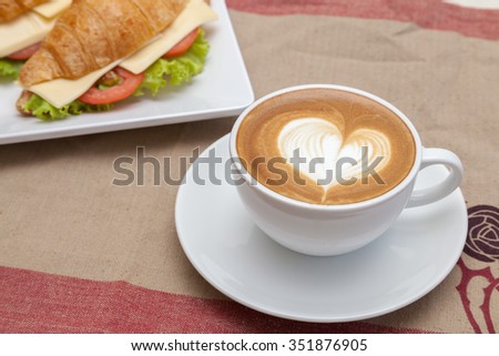 Having a cup of coffee with croissants in coffee shop