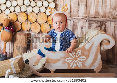 Cute baby boy sitting in a sleigh Christmas