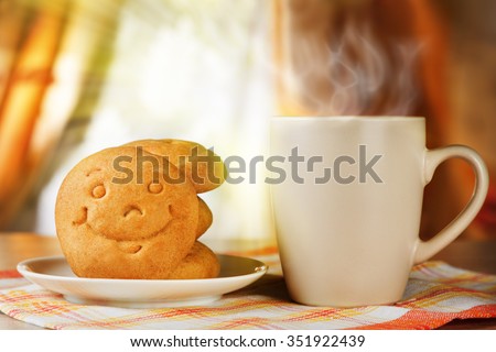 Breakfast for positive mood. A hot drink and biscuit with a smile