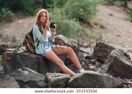 Girl takes photographs with vintage photo camera outdoor and looking far away