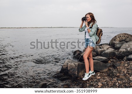 Girl takes photographs with vintage photo camera outdoor