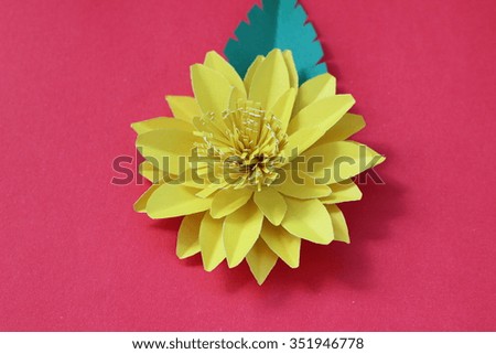 Many colorful paper flowers on a background with a smooth surface