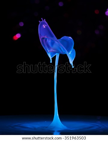 A colorful splash of liquid on a black background Royalty-Free Stock Photo #351963503
