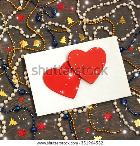 New Year's congratulation from heart, with love. A New Year's background with envelopes, decorative red jewelry in the form of heart, a beads and confetti, the top view.