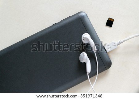 Phone accessories, usb cables, headphones on a white wood background