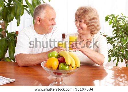 Happy elderly couple with fresh fruits.