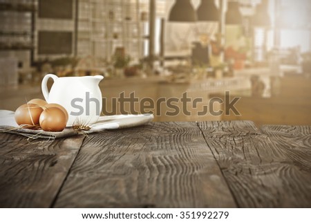 blurred background of kitchen and free space on dark brown table and milk and napkin 