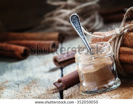 Ground cinnamon in a glass jar with a spoon, selective focus