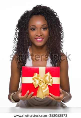 Young african-american woman with gift isolated in studio.