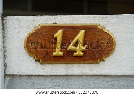 Number 14 on textured concrete wall 