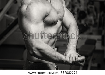 
Bodybuilder makes exercise with dumbbells at the gym. Work on hands tell muscles. Exhausting workouts to an end. Photos for sporting magazines and websites.

