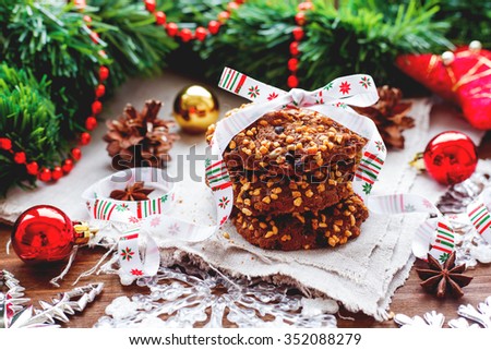 Christmas and New Year background with decorations, pine cones and stack of tasty cookies with holiday ribbon.