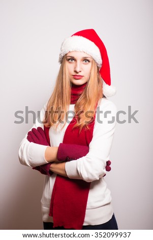 Christmas girl waiting for something. Santa hat isolated portrait of a woman on a gray background.