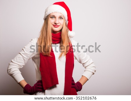 Christmas girl put her hands on her hips. Santa hat isolated portrait of a woman on a gray background.