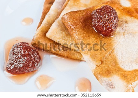 Pancakes with strawberry jam on a white plate