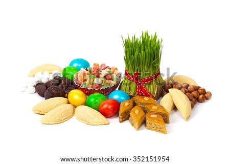 Novruz in Azerbaijan. Colored eggs for Easter and traditional sweets on white background. Selective focus.