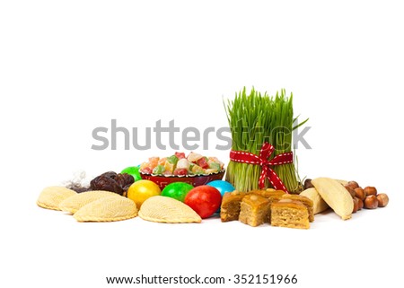 Nowruz in Azerbaijan. Colored eggs for Easter and traditional sweets on white background. Selective focus.