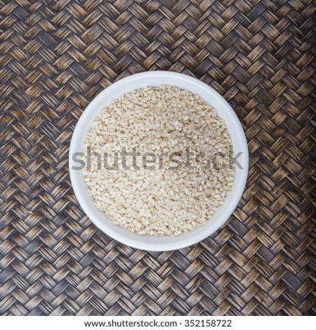 White sesame seed in white bowl over wicker background