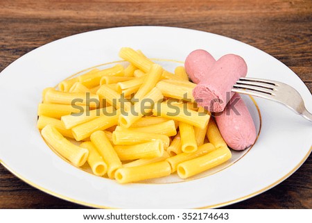 Eating Fast Food: Pasta with Sausage on Plate. Studio Photo