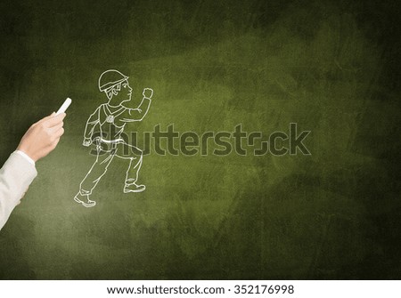 Male hand drawning with chalk construction man on blackboard