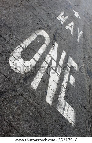 One way sign painted on the street ground.