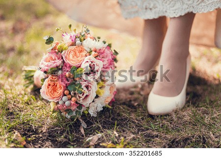 Bridal shoes and bouquet on the grass