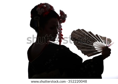 young pretty geisha in kimono with sakura and decoration. Portrait of a Japanese geisha woman isolated on white. silhouette of a girl with a fan