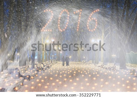 Severe weather in Kiev citizens favorite park, twilight hid fog and snowfall old trees, fall asleep benches, lights shine through the mist cold and damp, a strong wind blows snowflakes quickly through