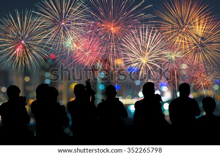 The silhouette of reporter photograph the Fantastic festive new years colorful fireworks on cityscape blurred photo bokeh,project success, holiday concept