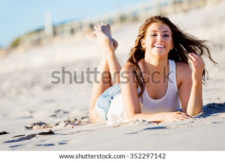 Portrait of young pretty woman relaxing on sandy beach