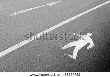 Pedestrian walking sign painted on asphalt pavement