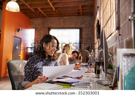 Team Of Designers Working At Desks In Modern Office Royalty-Free Stock Photo #352303001