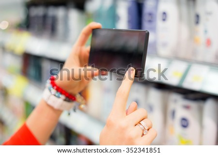 Woman taking picture in supermarket 
