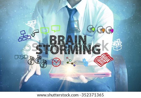 businessman holding a tablet computer with BRAIN STORMING text ,business concept 