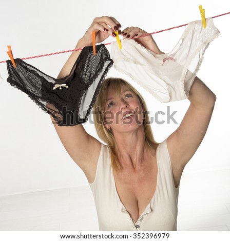Woman hanging out her underwear on the washing line to dry Royalty-Free Stock Photo #352396979