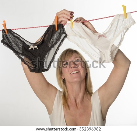 Woman hanging out her underwear on the washing line to dry Royalty-Free Stock Photo #352396982