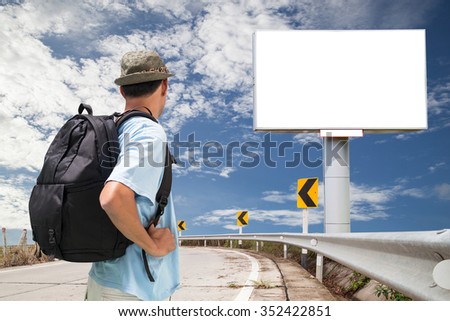  Male tourist with backpack looking Blank billboard for your advertisement on road curve
