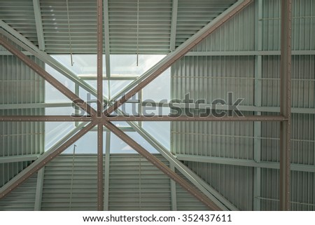 Vertical view of  a glass skylight and steel roof in tones of blue, white, and gray/grey.