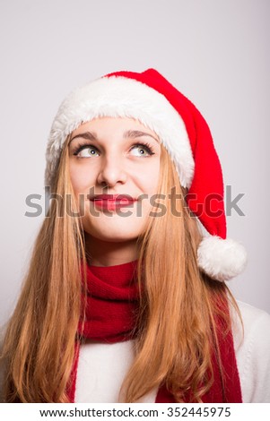 Christmas girl has a good idea. Santa hat isolated portrait of a woman on a gray background.
