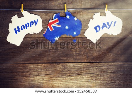 Australia day Concept - greeting written across white Australian maps, kangaroos and koala, hanging pegs, 26 January. toned image. sunlight effect