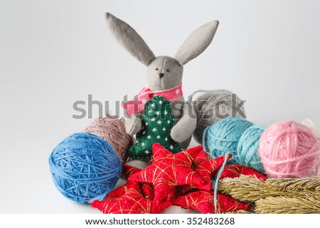 Hobby needlework concept. Handmade felt toy bunny with colored wool clew