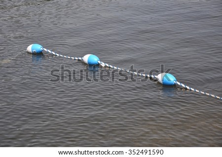Three floating marker buoys linked together with rope