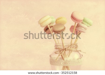 Colorful macaroons on wooden sticks in a glass jar 