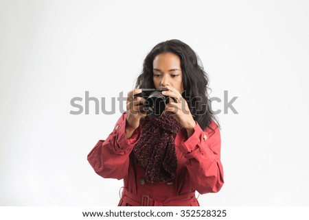 Beautiful woman taking  pictures with rose raincoat, brown wool scarf